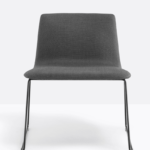 Chair upholstered with fabric or synthetic leather and tubular steel sled frame.
